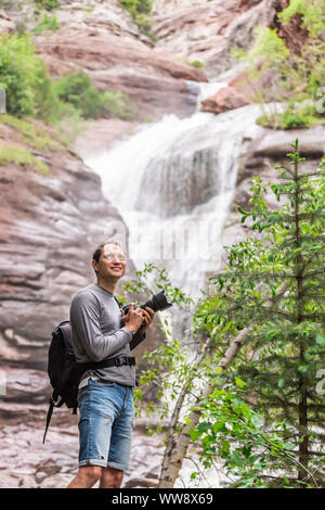 Hays creek falls in Redstone, Colorado during summer with man photographer standing with camera happy smiling Stock Photo