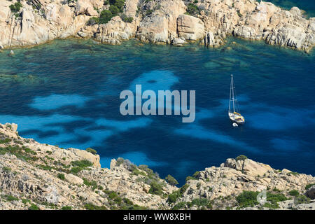 View from above, stunning aerial view of a sailboat floating on a turquoise clear water. Cala Coticcio (also known as Tahiti), Sardinia, Italy. Stock Photo