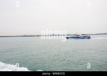 BATAM, INDONESIA - 12 DECEMBER 2018: Ferry and ships transporting passengers during morning from JB ferry center to batam center, beautiful forest bac Stock Photo