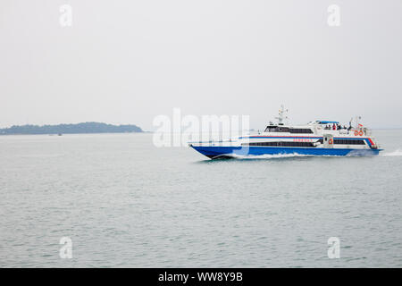 BATAM, INDONESIA - 12 DECEMBER 2018: Ferry and ships transporting passengers during morning from JB ferry center to batam center, beautiful forest bac Stock Photo