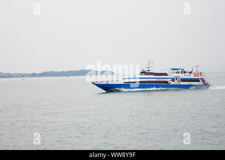 BATAM, INDONESIA - 12 DECEMBER 2018: Ferry and ships transporting passengers during morning from JB ferry center to batam center, beautiful forest bac Stock Photo