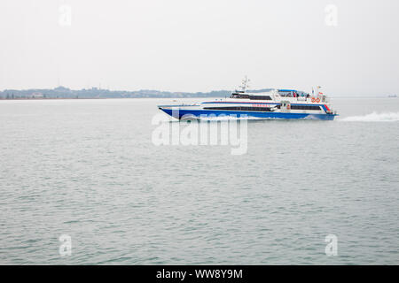 BATAM, INDONESIA - 12 DECEMBER 2018: Ferry and ships transporting passengers during morning from JB ferry center to batam center, beautiful forest bac Stock Photo