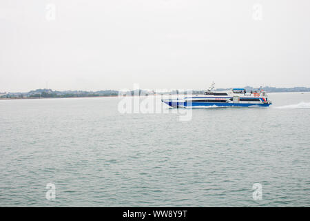 BATAM, INDONESIA - 12 DECEMBER 2018: Ferry and ships transporting passengers during morning from JB ferry center to batam center, beautiful forest bac Stock Photo