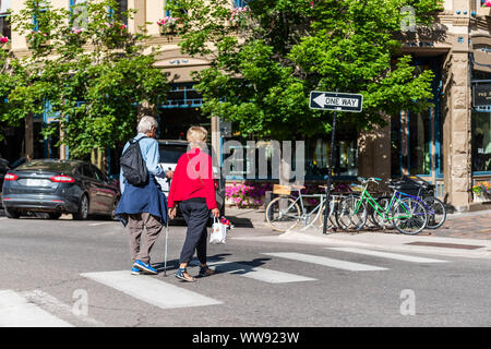 Aspen, USA - July 6, 2019: People older couple crossing street in historic downtown outdoor summer street in Colorado Stock Photo