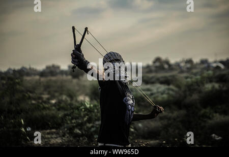 Gaza, Palestine. 13th Sep, 2019. A Palestinian demonstrator uses a slingshot to throw stones during an anti-Israel demonstration at the Israel-Gaza border fence in the southern Gaza Strip. Credit: SOPA Images Limited/Alamy Live News Stock Photo