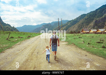 father and daughter go camping on the road near the mountains Stock Photo