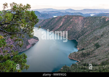 Tree framing view from Canyon Rim Campground in Flaming Gorge Utah National Park of Green River high angle aerial overlook in dark evening Stock Photo