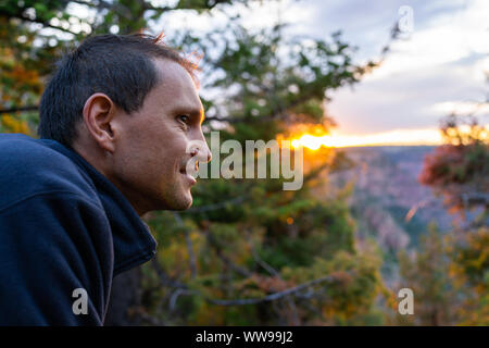 Happy man looking at view of sunset from Canyon Rim Campground in Flaming Gorge Utah National Park of Green River in dark evening Stock Photo