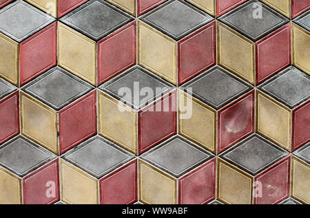 Colorful geometric tiles on the ground. Diamond shaped tiles of gray, yellow and red colors. Abstract background with cubes pattern Stock Photo