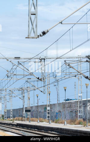 Blue sky with white clouds and stone background wall in wire fence. Stock Photo