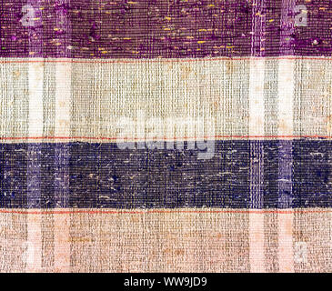 Vintage homespun doormat made from strips of cloth as background. Texture of a homemade rug from different fabrics Stock Photo