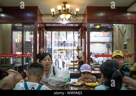 Xian, China -  July 2019 : Chinese family dining in a small local restaurant in the Muslim Quarter Stock Photo