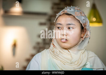 Xian, China -  July 2019 : Muslim woman photographed inside her food stall on the food street in the Muslim Quarter Stock Photo