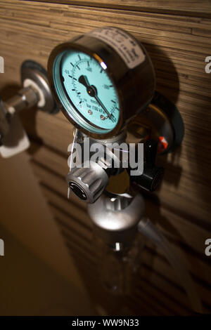 Selective focus on the pressure gauge of an oxygen support system mounted on the wall of a luxury hospital room. Stock Photo