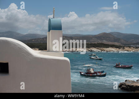 Naxos, Greece - June 28, 2018: A traditional building with a blue arch and a cross on top sits seaside in Alykó, on the southwestern shore of the isla Stock Photo