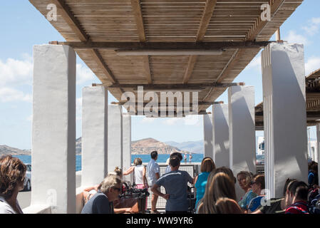 Naxos, Greece - June 28, 2018: Travellers wait for a ferry at the Port of Naxos. Stock Photo