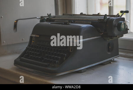 Old retro typewriter standing on the windowsill. Stock Photo