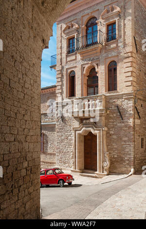 Red vintage Italian car Fiat 500 in an Italian alley inside Assisi Stock Photo