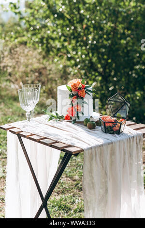 Freshly decorated wedding and celebration cake on a table outdoors. Stock Photo