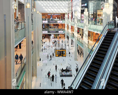 Dubai Mall modern interior design, the biggest mall in the world - Tourist attractions and landmarks in Dubai, UAE - people shopping Stock Photo