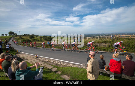 The city of Manchester is seen in the distance as competitors cycle across the top of Werneth Low Country Park during stage eight of the OVO Energy Tour of Britain from Altrincham to Manchester. Stock Photo