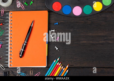 School stationery supplies and watercolors on dark background. Back to school concept Stock Photo
