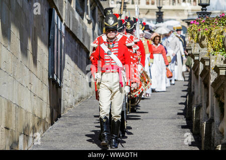 Bath, Somerset, UK. 14 Sep, 2019. Members of the re-enactment group, His Majesty’s 33rd Regiment of Foot taking part in the world famous Grand Regency Costumed Promenade are pictured as they enter Parade Gardens. The Promenade, part of the 10 day Jane Austen Festival is a procession through the streets of Bath and the participants who come from all over the world dress in 18th Century costume. Credit:  Lynchpics/Alamy Live News Stock Photo