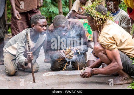 Pygmy tribesmen make fire, Uganda Stock Photo