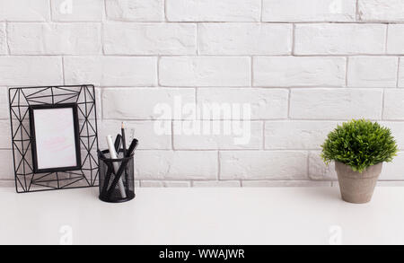 Modern office table with frame for photo and green plant Stock Photo