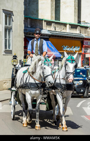 Horse-drawn carriage (fiaker) carrying tourists around the Ringstrasse ring road, Vienna, Austria. Stock Photo
