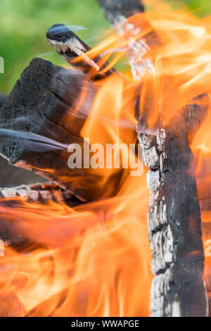 Fireplace burning. Warm cozy burning fire in a brick fireplace close up. Cozy background. Bonfire in nature. Fire background. Vertical photo. Stock Photo