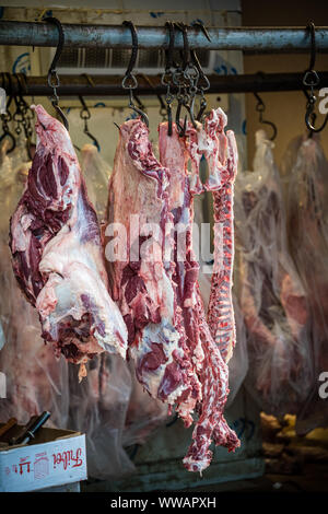 Xian, China -  July 2019 : Lamb and cow carcass meat hanging on a hook on the street food vendors shop in the Muslim quarter of Xian town, Shaanxi Pro Stock Photo