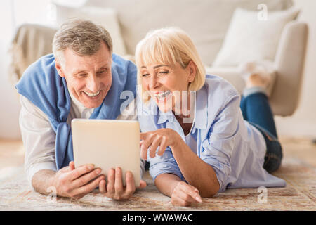 Senior couple using tablet pc having video call with grandkids Stock Photo