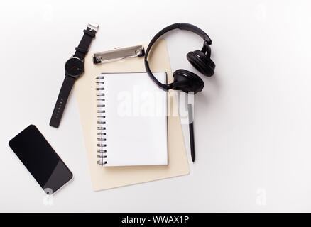 Cellphone, notebook and headphones on white background Stock Photo