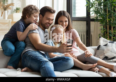 Joyful family making selfie shot on smartphone. Stock Photo