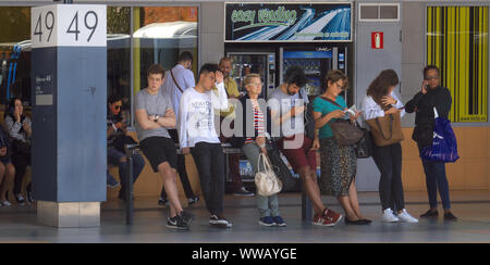 Mixed-gender race and age people waiting in line queuing for bus in Madrid. Stock Photo