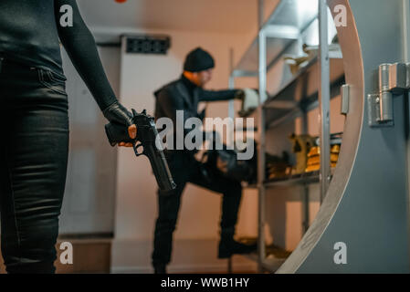 Two robbers in black uniform hacked the vault Stock Photo