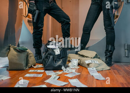 Two robbers poses with money at the vault Stock Photo