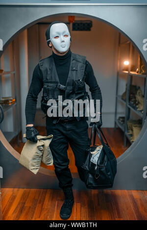 Bank robbery, robber in black uniform and mask Stock Photo