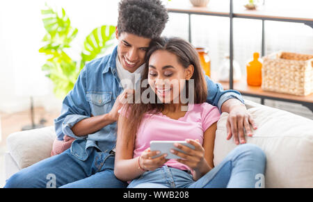African american teens watching videos online on smartphone Stock Photo