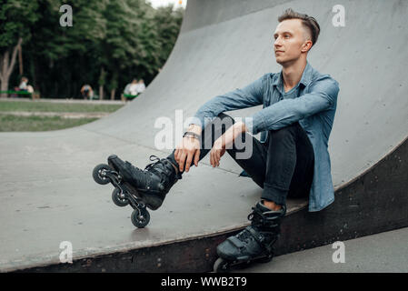 Roller skating, male skater poses on the ramp Stock Photo