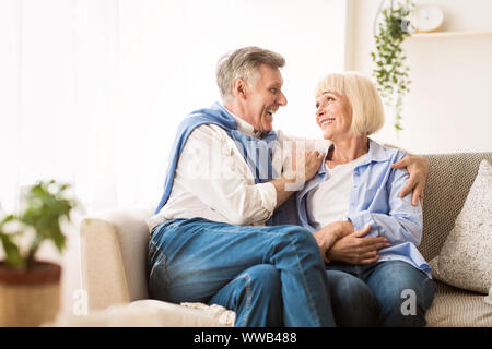 Senior affectionate couple relaxing on sofa at home Stock Photo