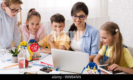 Smart pupils with teacher enjoying science robotics lessons Stock Photo
