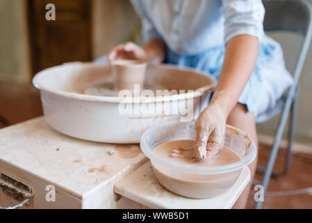 Female master making a pot on pottery wheel Stock Photo