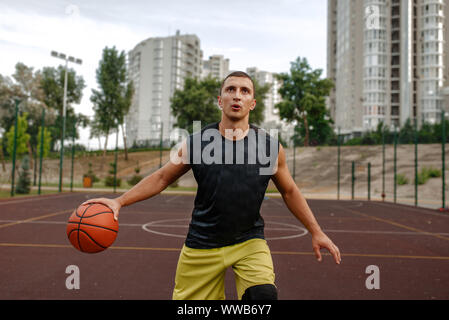 Basketball player in motion on outdoor court