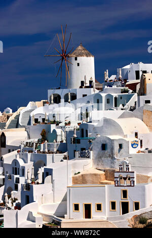 Partial view of the west part of Oia village, with one of its famous windmills, hanging over the caldera.Santorini island, Cyclades, Greece. Stock Photo