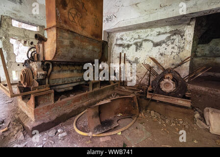 Old abandoned industrial machine tools and rusty metal equipment in abandoned factory . Stock Photo