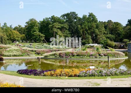 Water feature and colorful, blooming flowers in relaxing Parc Floral de Paris, France Stock Photo