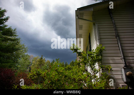 dark clouds above the roof of a home before a storm Stock Photo