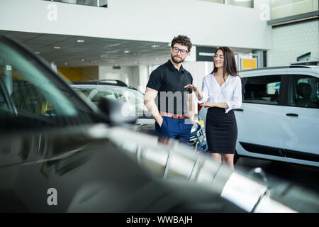 Professional salesperson selling cars at dealership to buyer Stock Photo